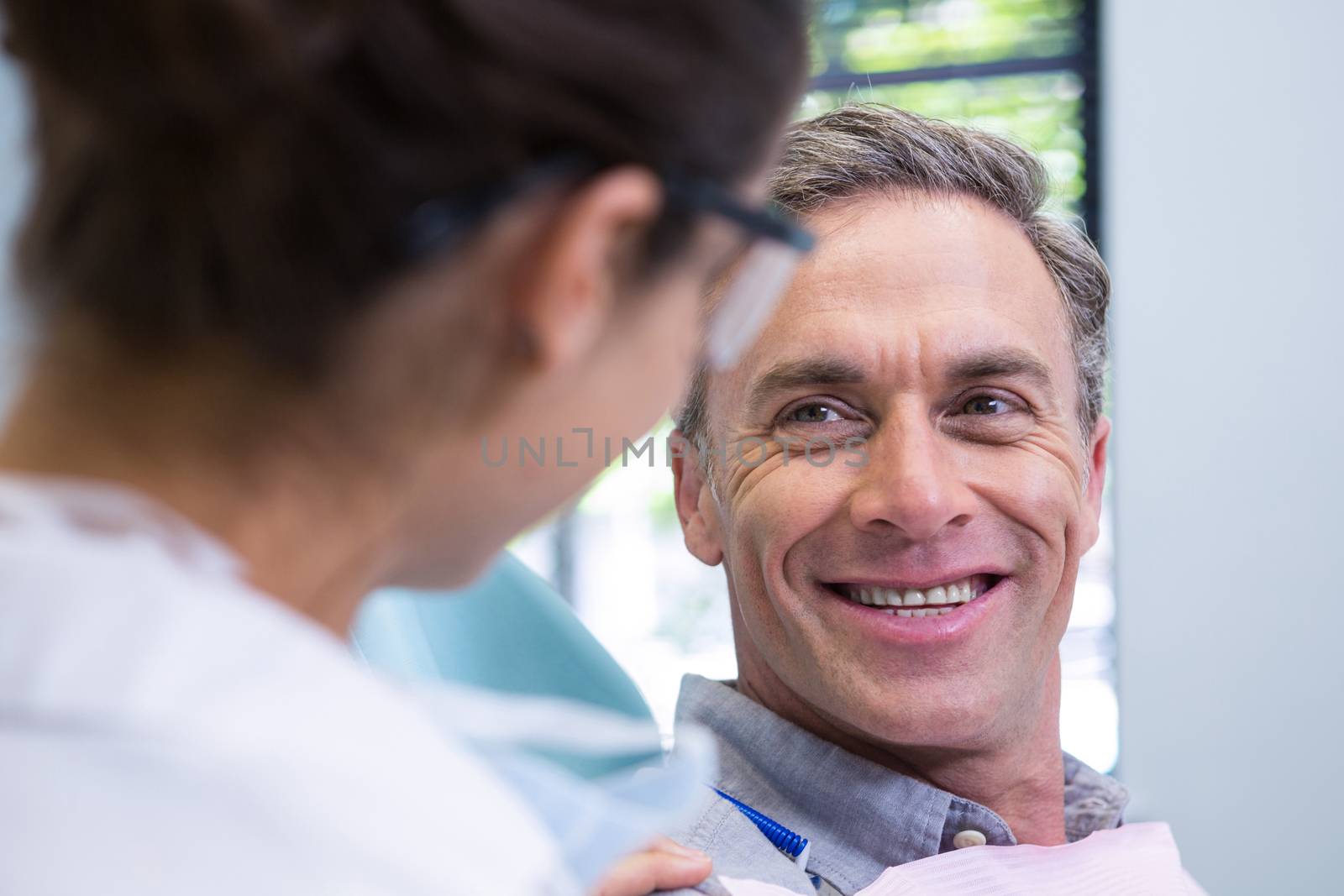 Close up of happy patient looking at dentist by Wavebreakmedia