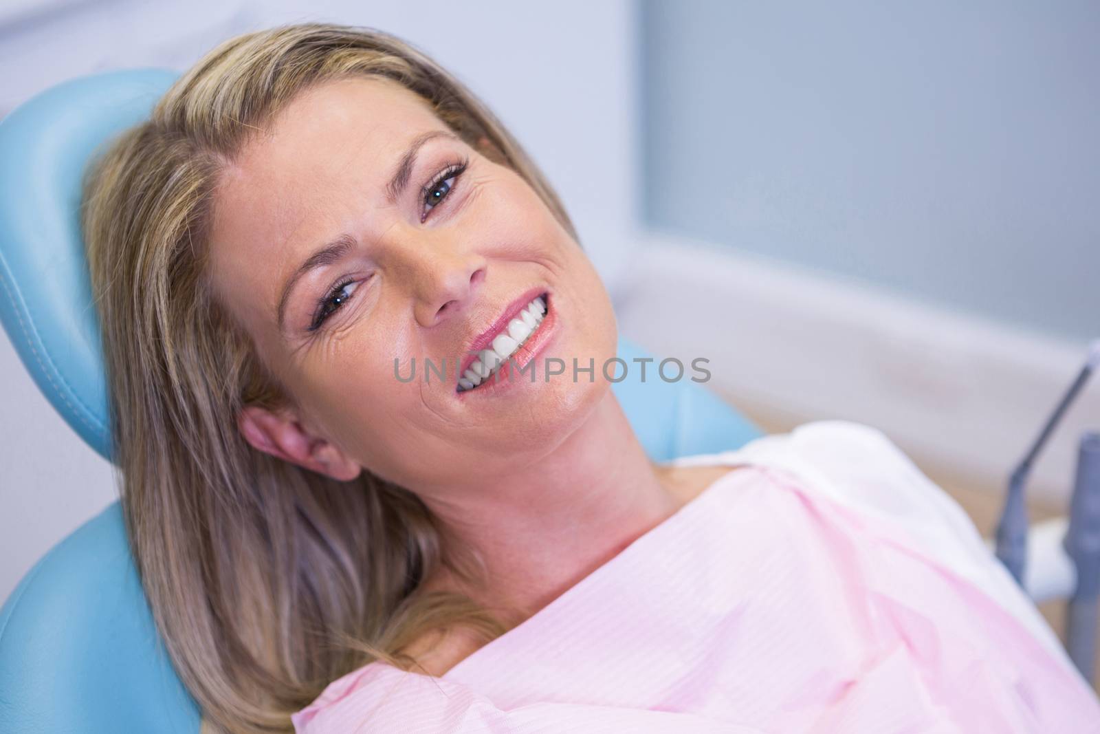 Portrait of smiling patient sitting on dentist chair by Wavebreakmedia