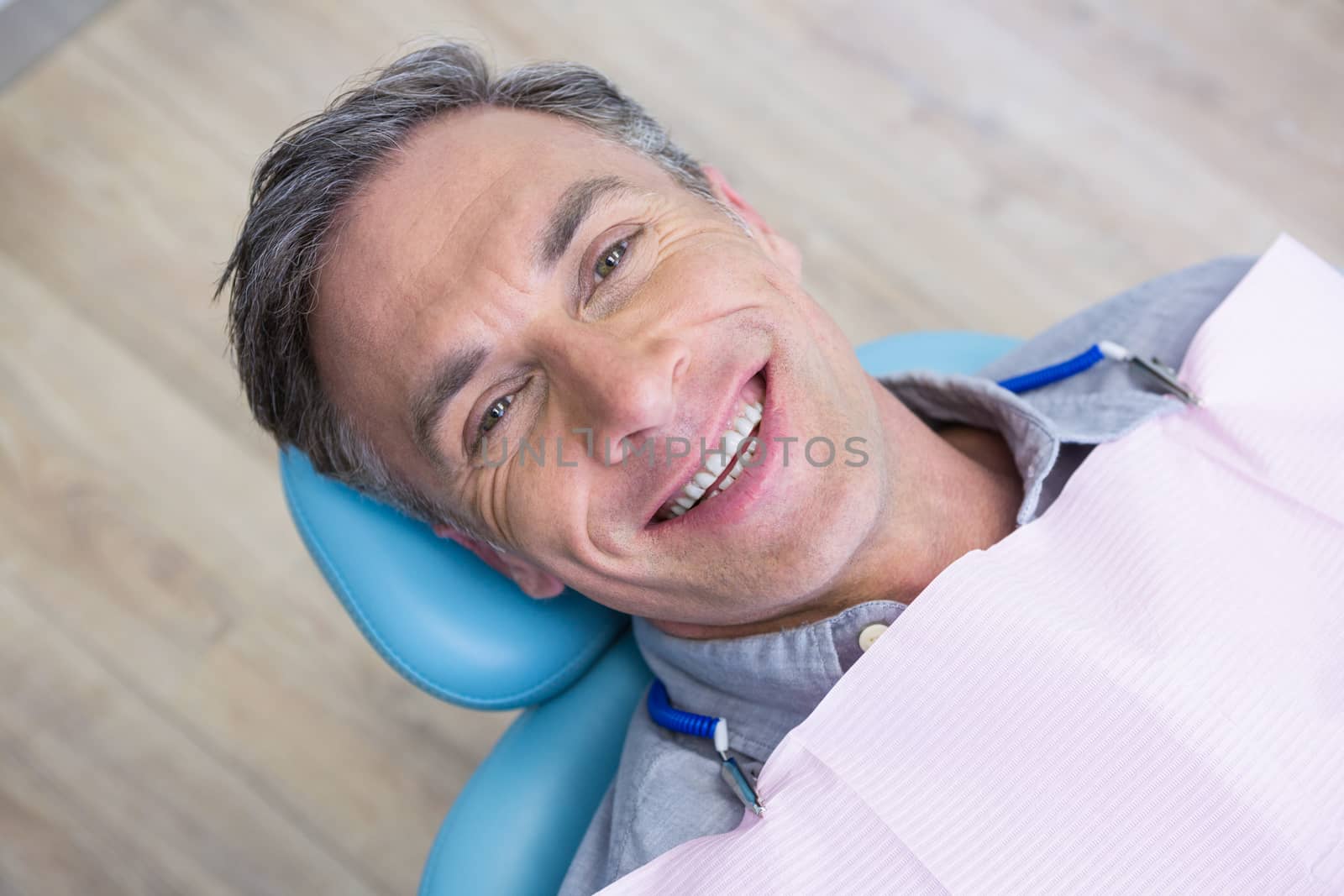 Overhead portrait of smiling man sitting on chair by Wavebreakmedia