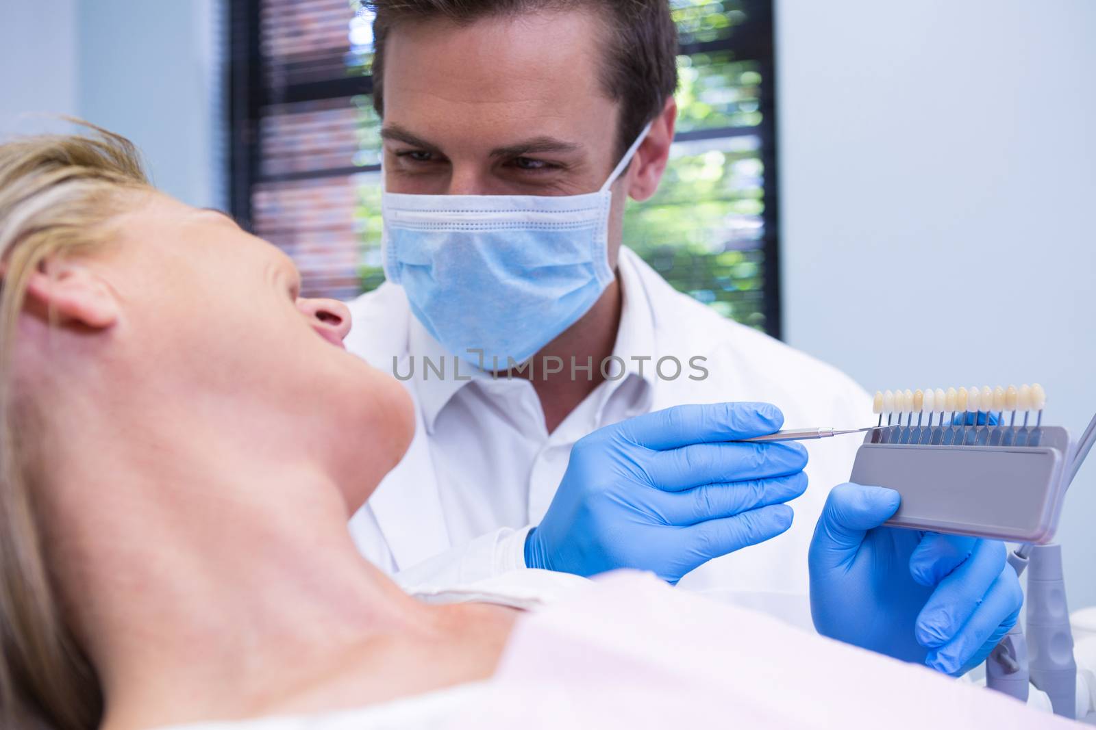 Close up of dentist showing equipment to patient by Wavebreakmedia
