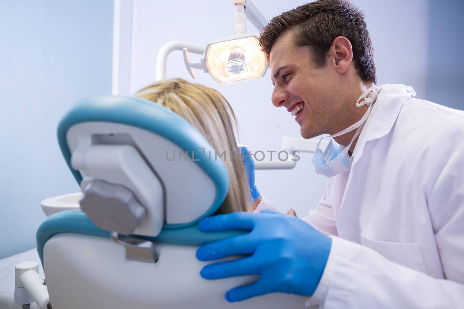 Happy dentist examining woman at medical clinic