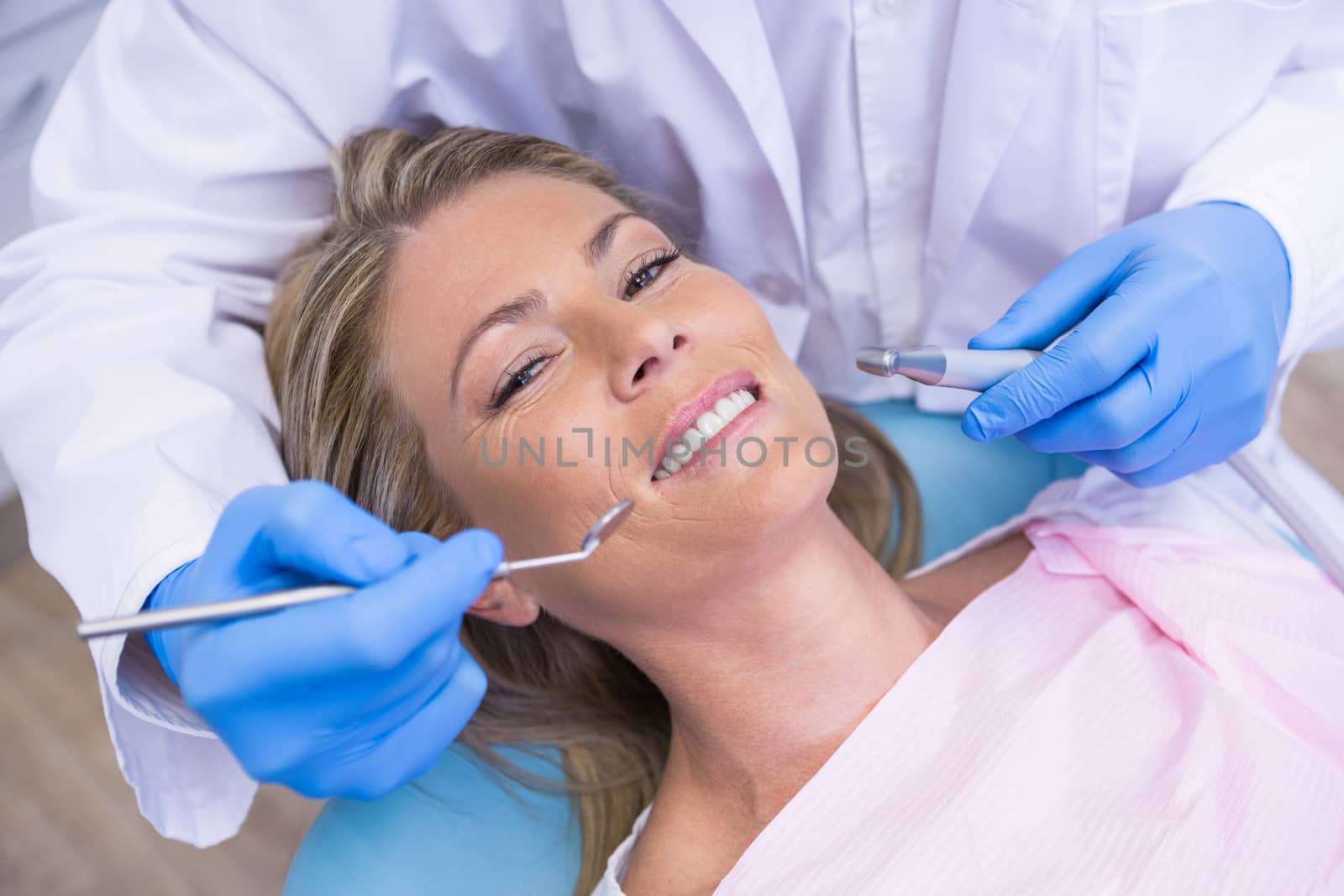 High angle portrait of woman by dentist dolding tool by Wavebreakmedia