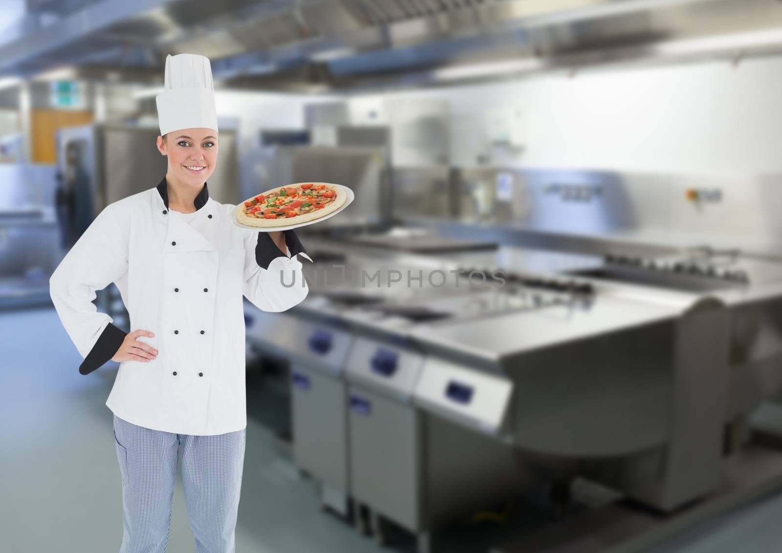 Chef with pizza in the restaurants kitchen by Wavebreakmedia