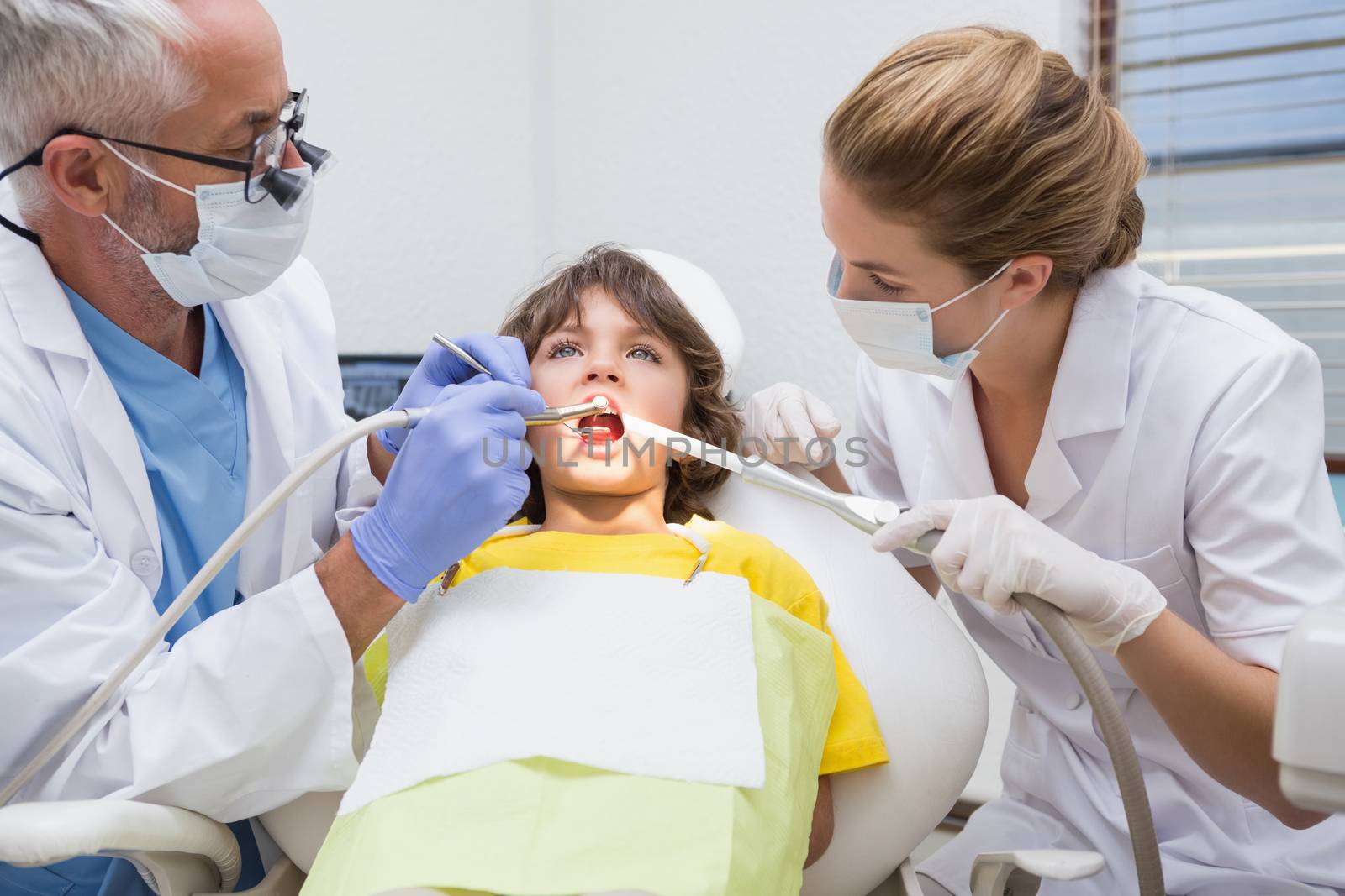 Pediatric dentist examining a little boys teeth in the dentists chair by Wavebreakmedia