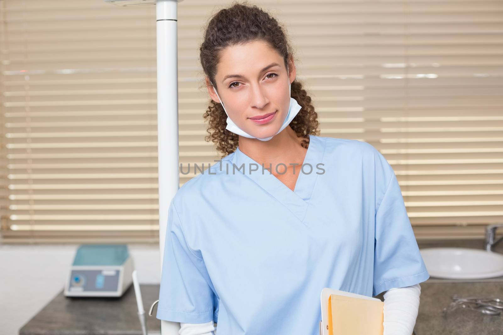 Dentist in blue scrubs looking at camera at the dental clinic