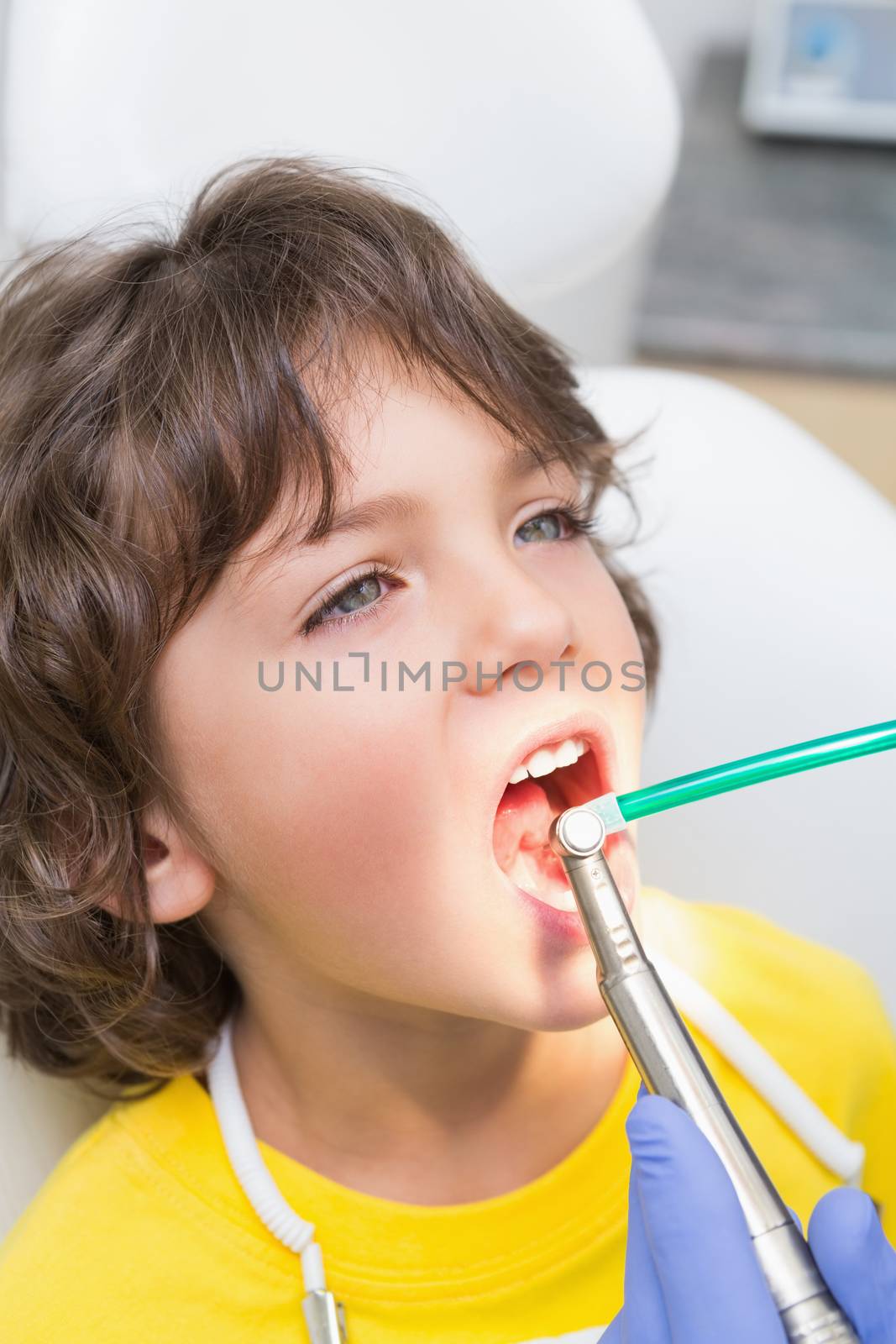 Pediatric dentist examining a little boys teeth in the dentists chair by Wavebreakmedia