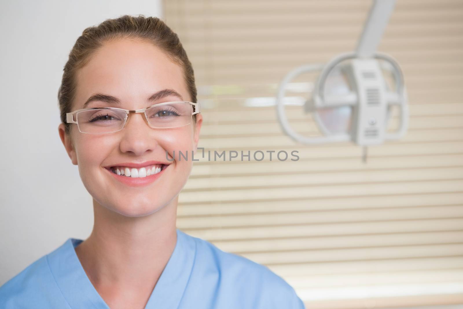Dentist in blue scrubs looking at camera by Wavebreakmedia