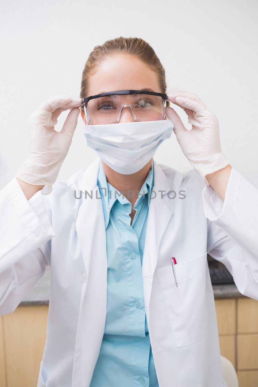 Dentist putting on her protective glasses by Wavebreakmedia