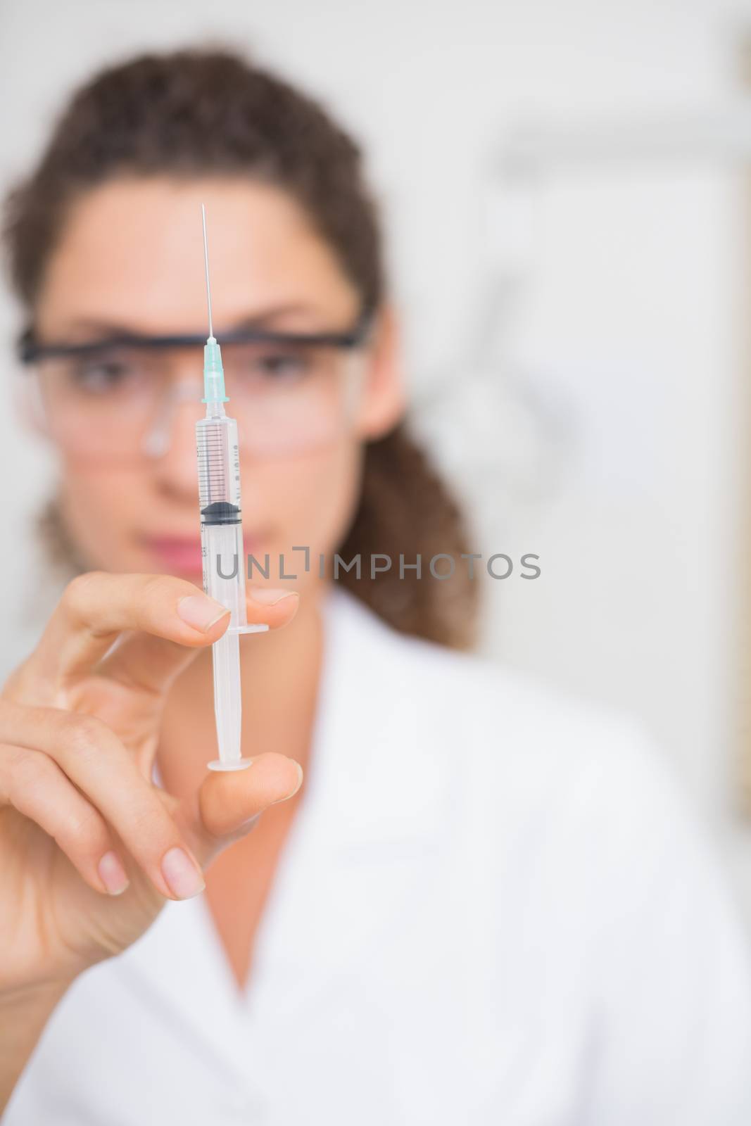Dental assistant preparing an injection by Wavebreakmedia