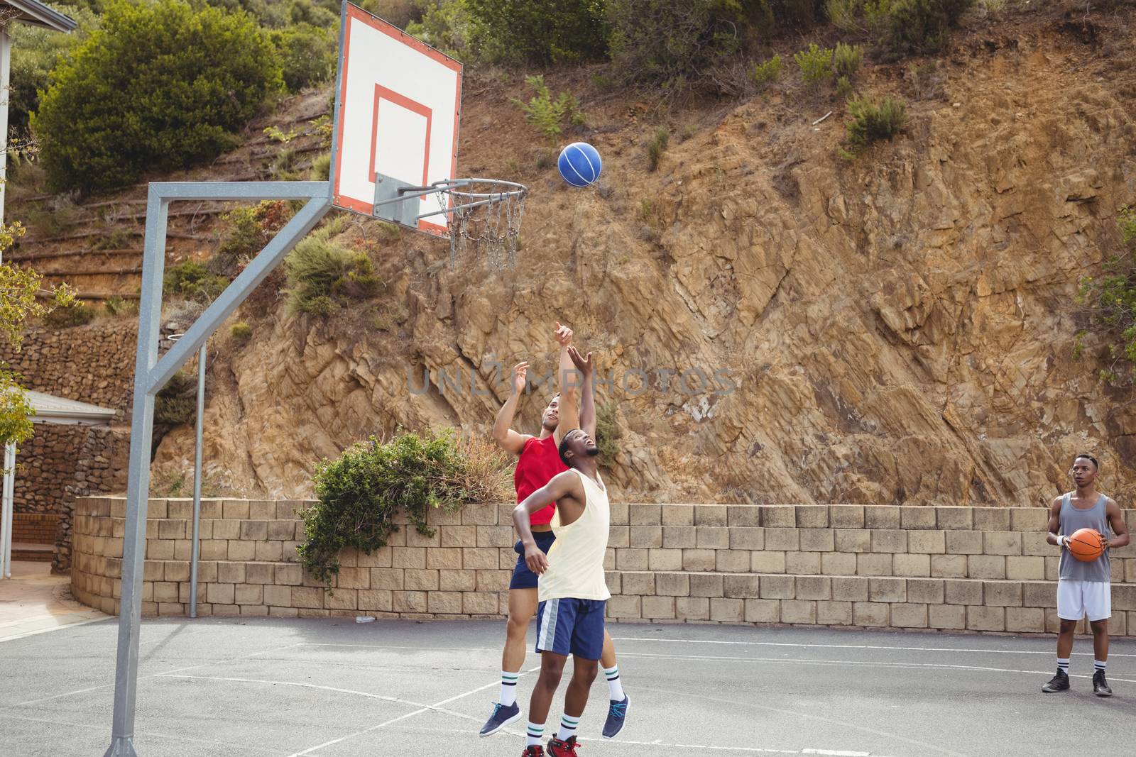 Basketball players playing in basketball court by Wavebreakmedia