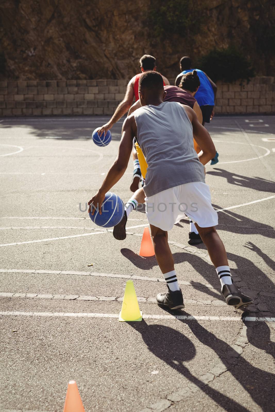 Basketball players practicing dribbling drill by Wavebreakmedia