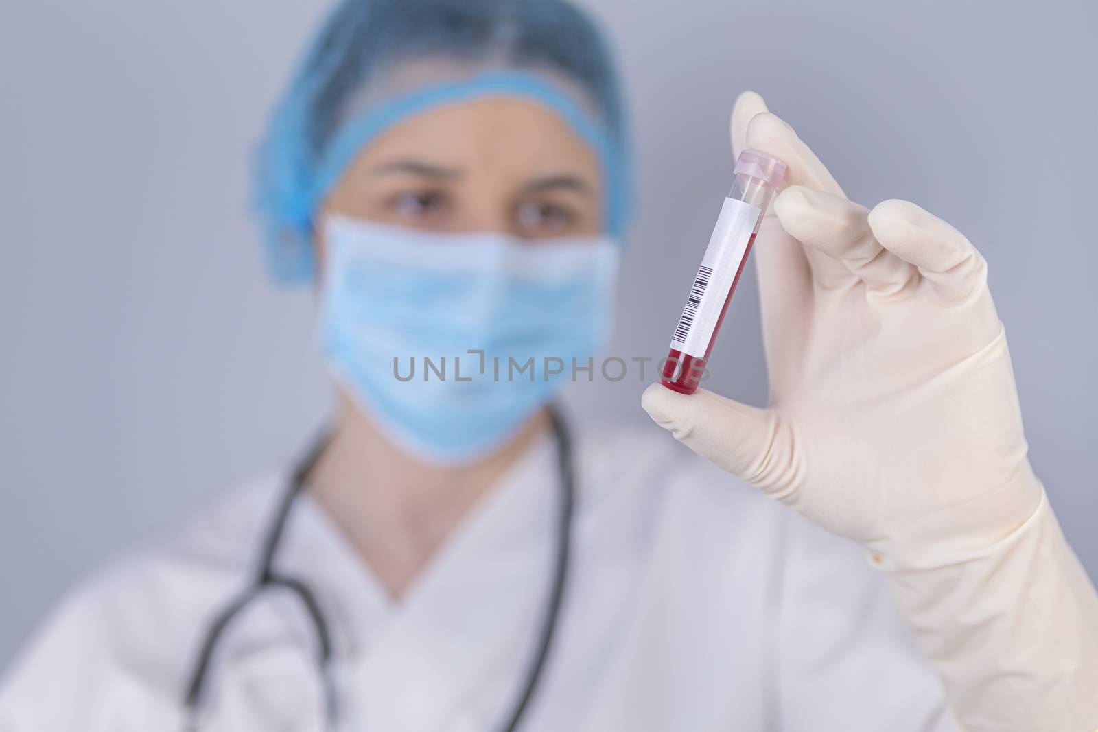 Nurse holding test tube blood sample by manaemedia