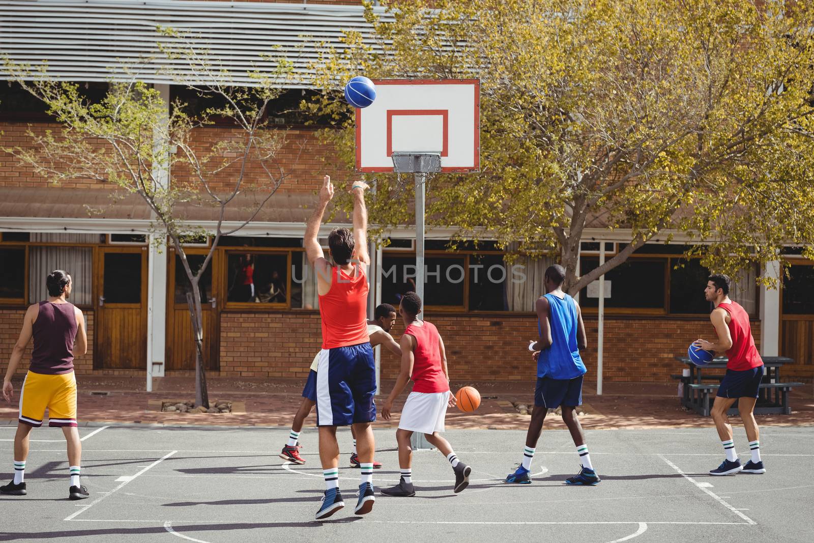Basketball players practicing in basketball court by Wavebreakmedia