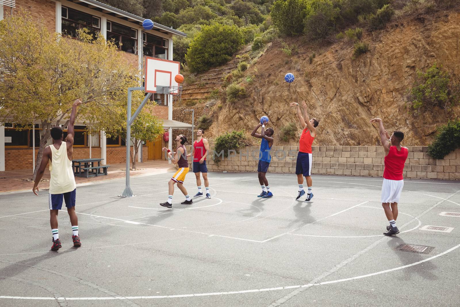 Basketball players practicing in basketball court by Wavebreakmedia