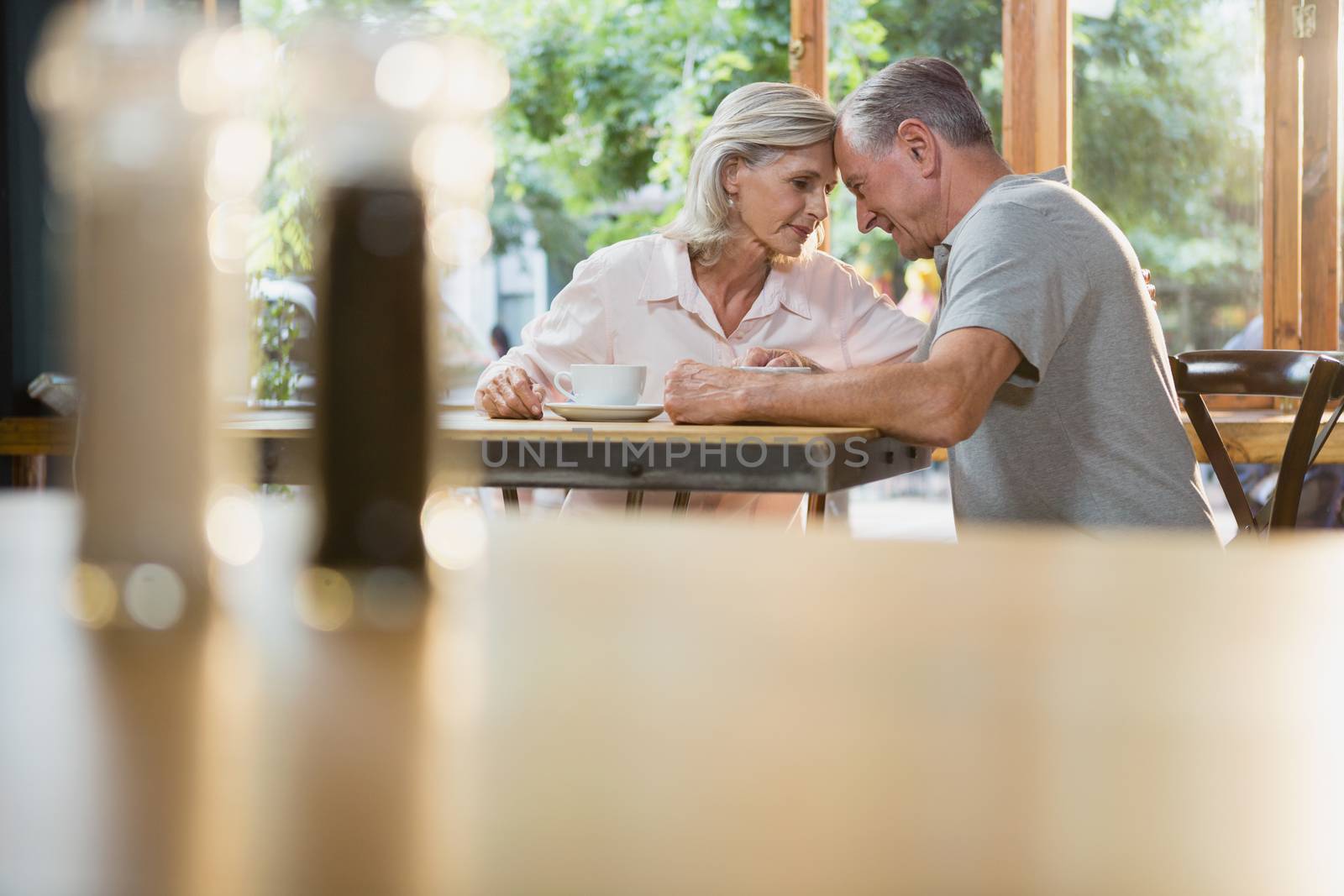 Romantic senior couple sitting together in cafÃ©