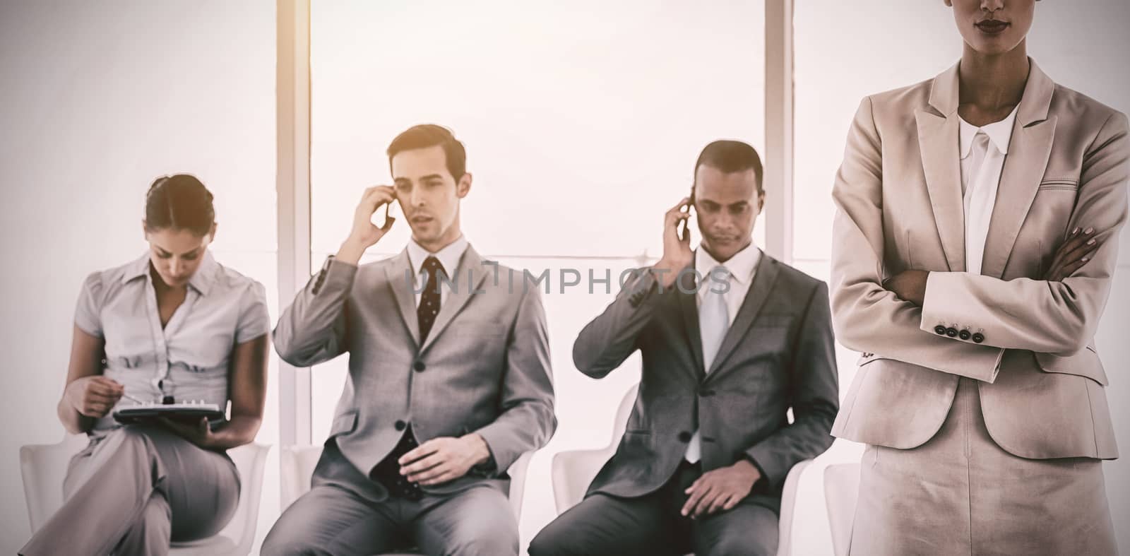 Businesswoman standing in front of business people waiting in a row