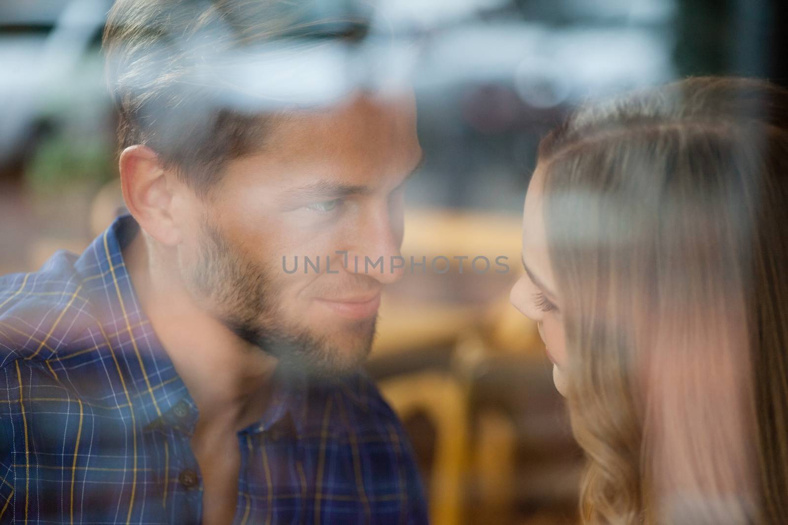 Close up of romantic couple in cafe seen through glass window