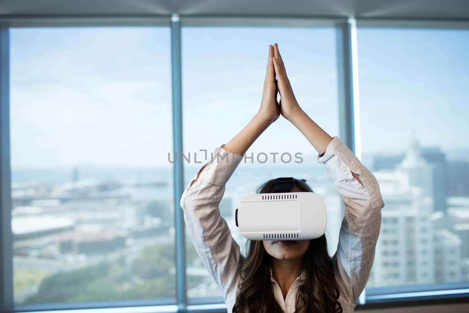 Businesswoman practicing yoga while using virtual reality glasses at office