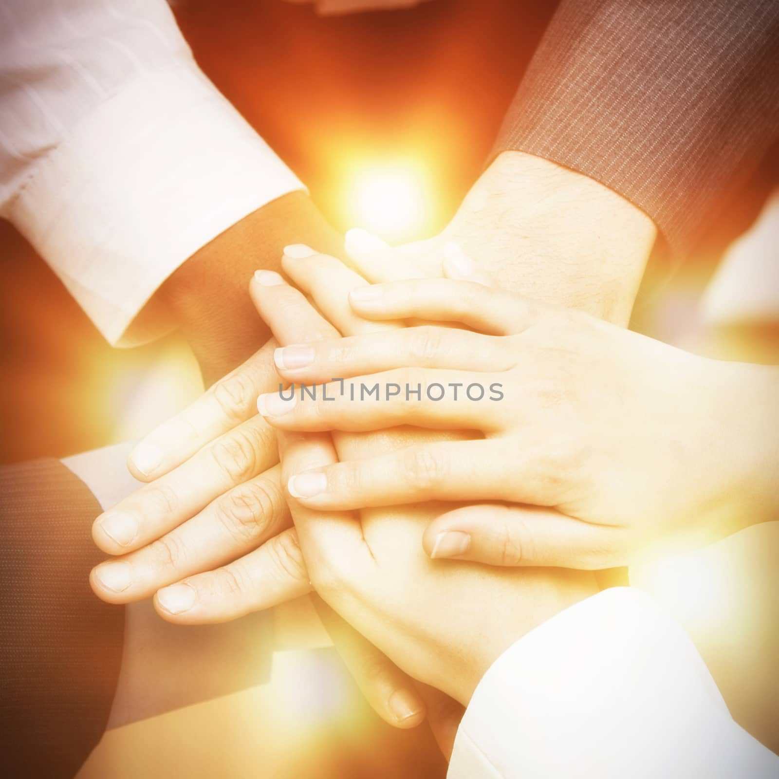 Close-up of colleagues stacking hands in office