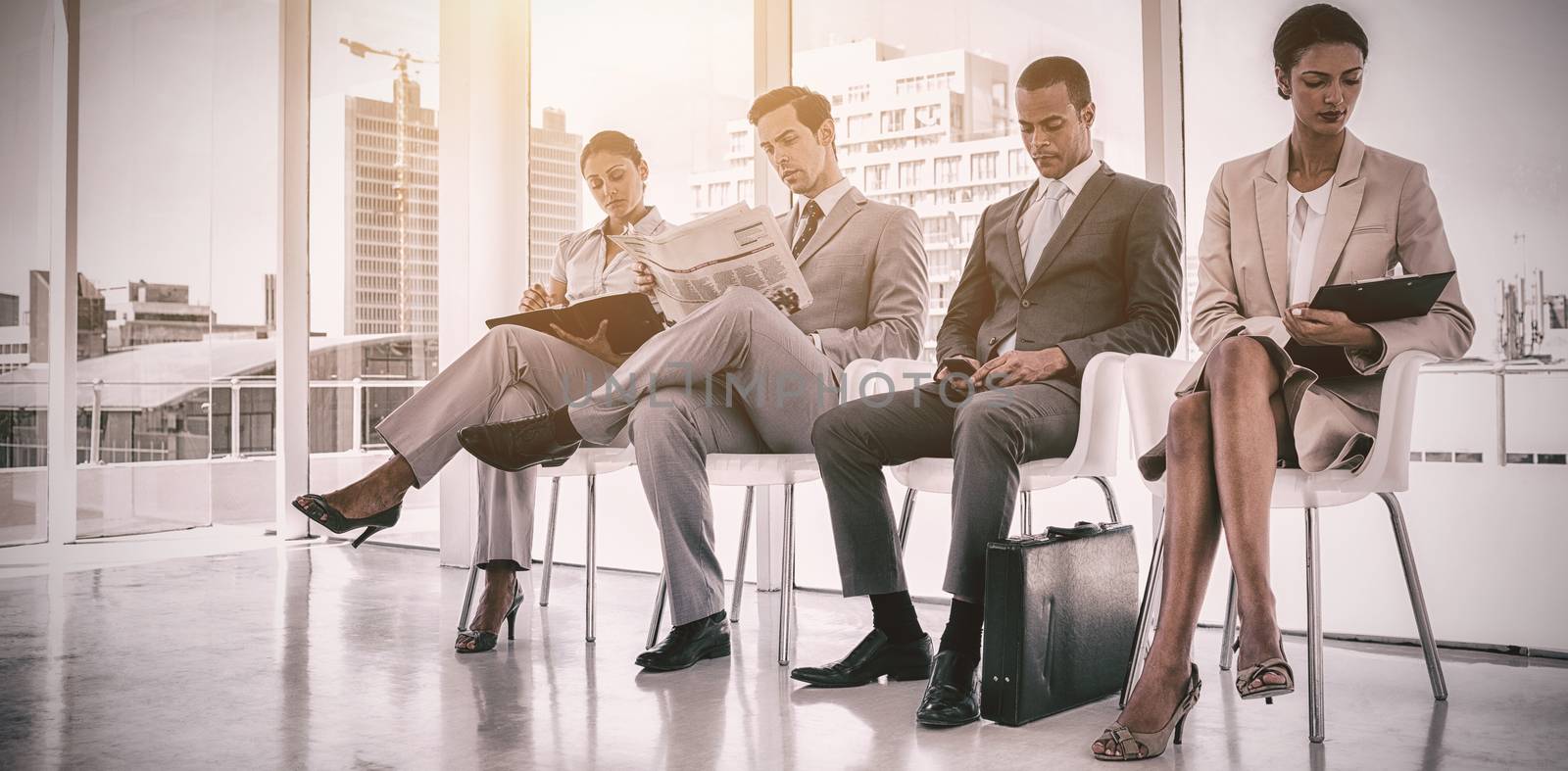 Well dressed business people sitting together by Wavebreakmedia