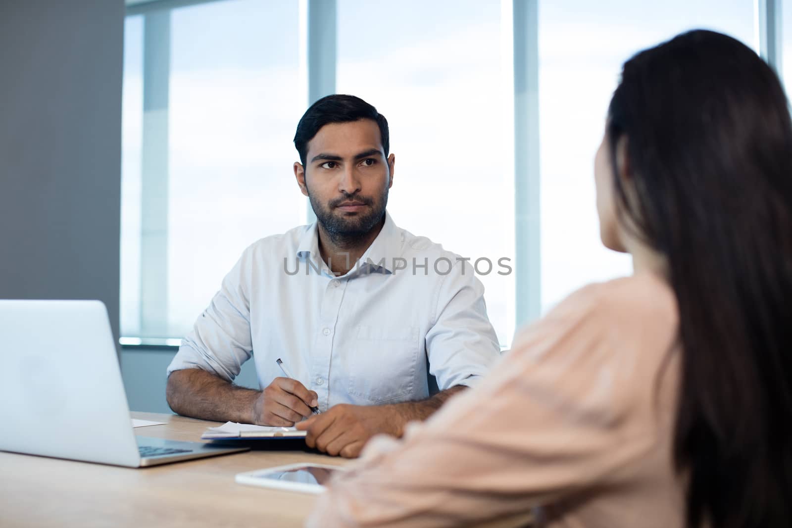 Business people discussing over contract in conference room