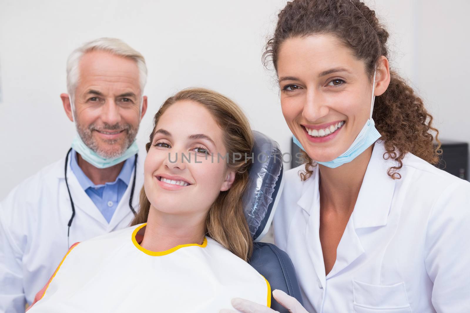 Dentist his assistant and patient all smiling at camera by Wavebreakmedia
