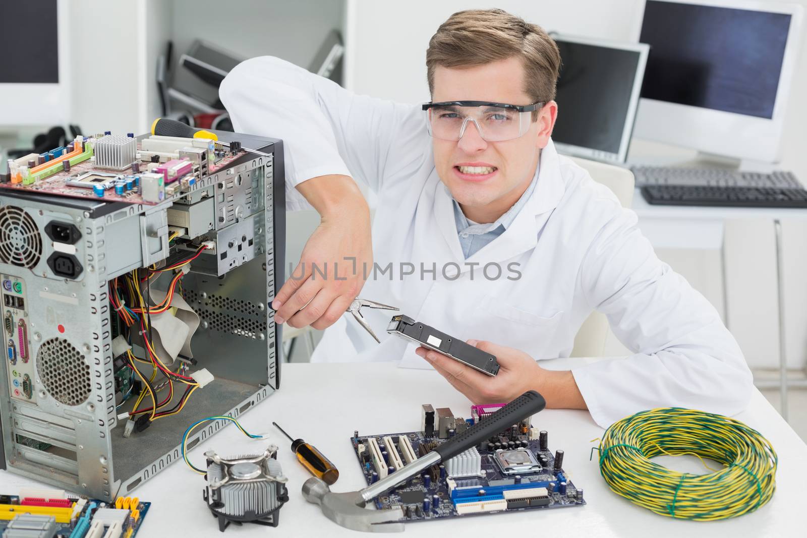 Angry computer engineer working on broken device by Wavebreakmedia