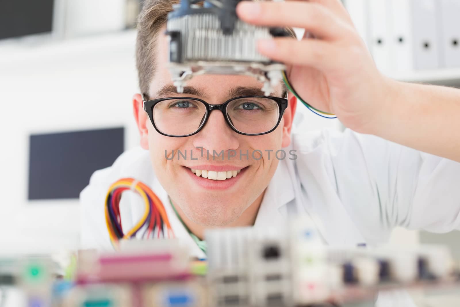 Smiling technician working on broken cpu in his office