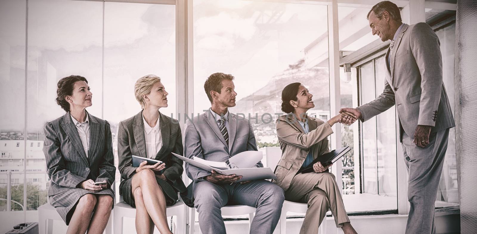 Manager welcoming people waiting for interview in office 