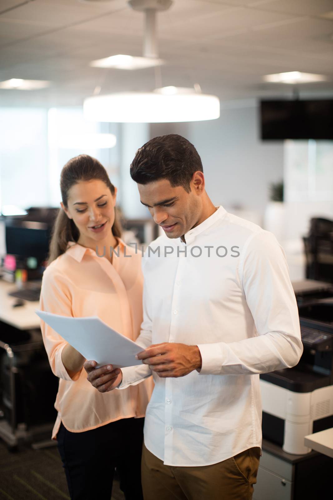 Business people discussing over documents in modern office
