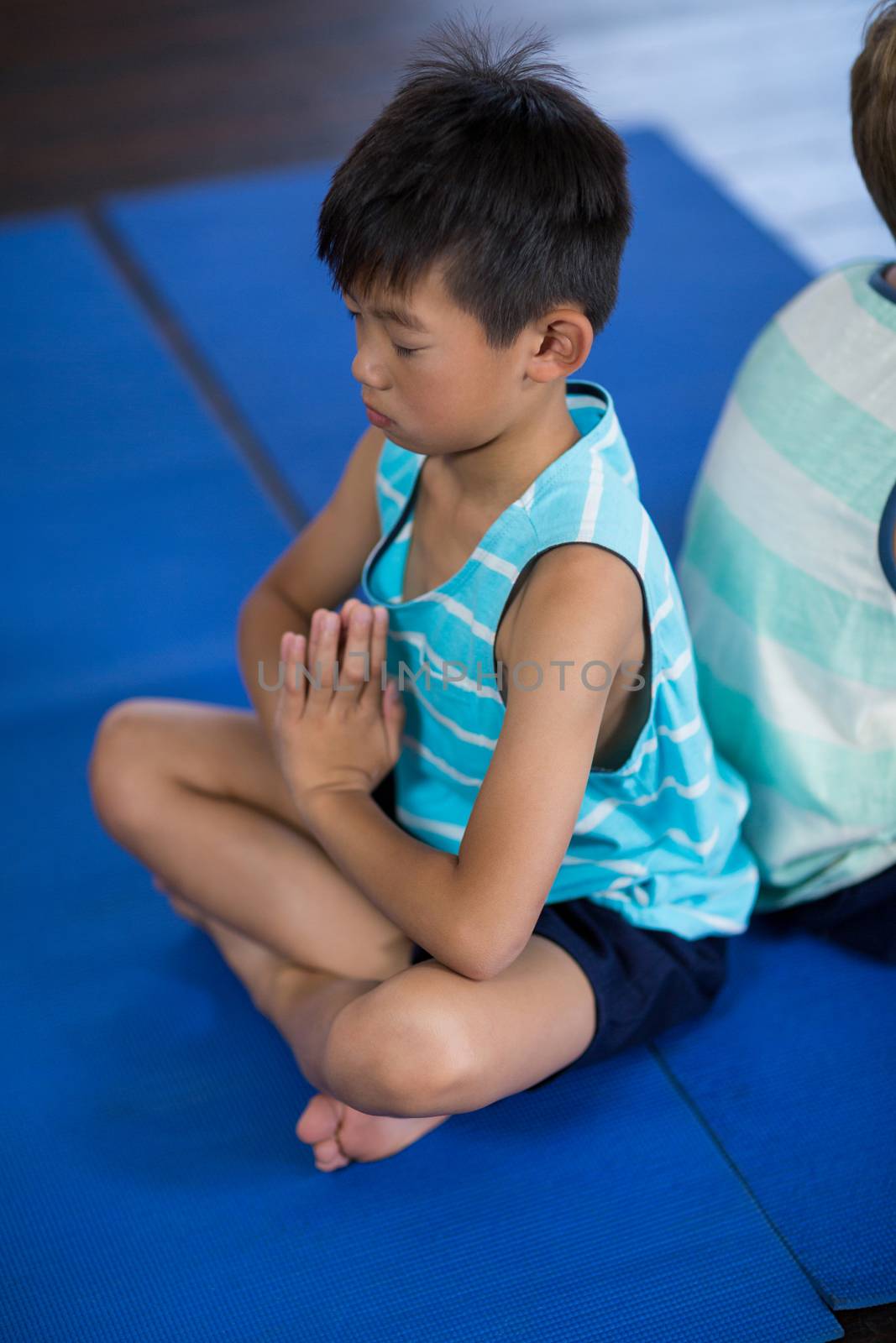 Side view of siblings performing yoga at home