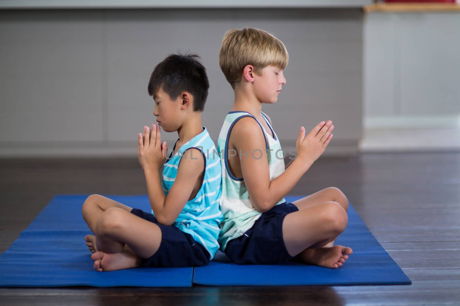 Siblings performing yoga at home by Wavebreakmedia