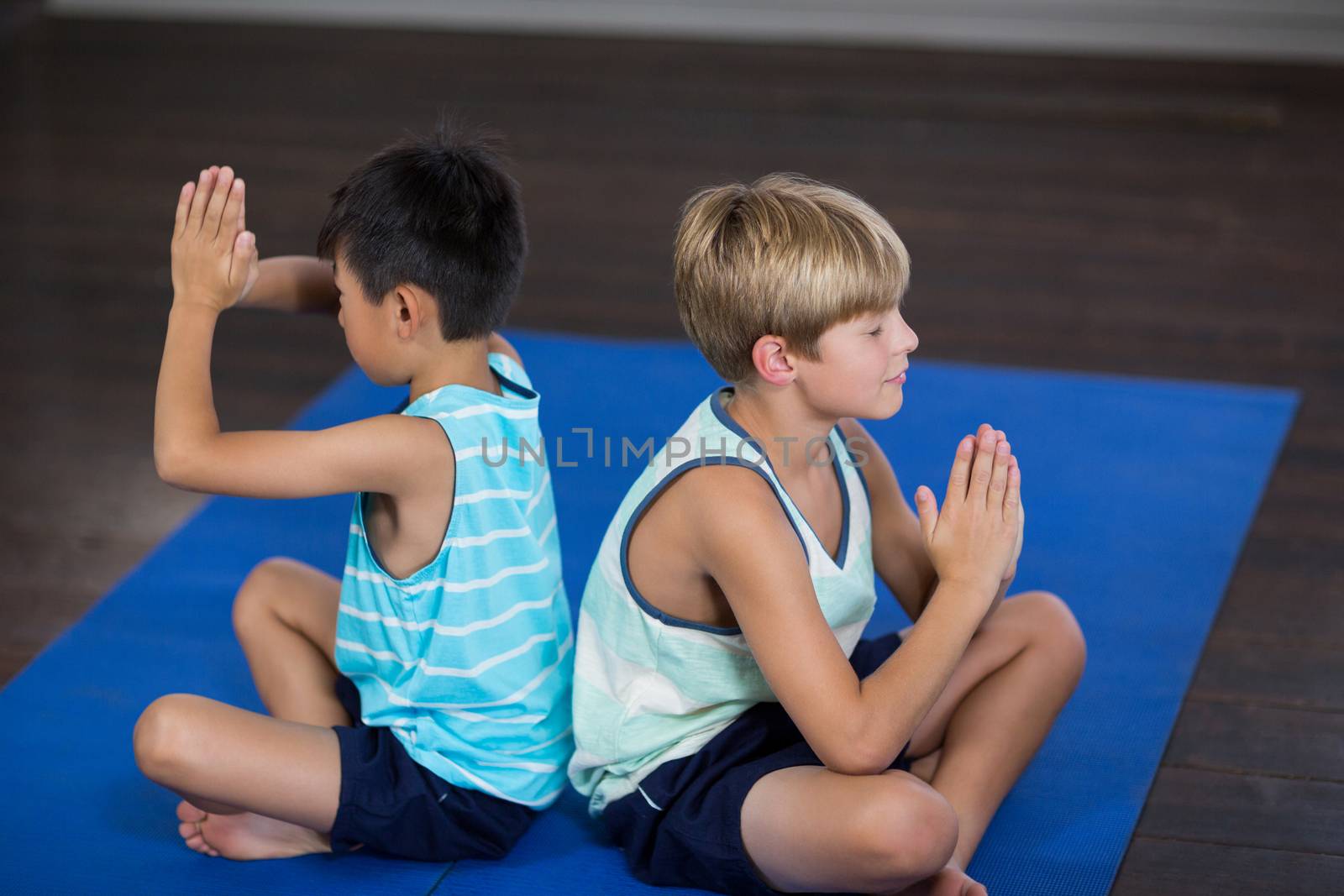 Siblings performing yoga at home by Wavebreakmedia