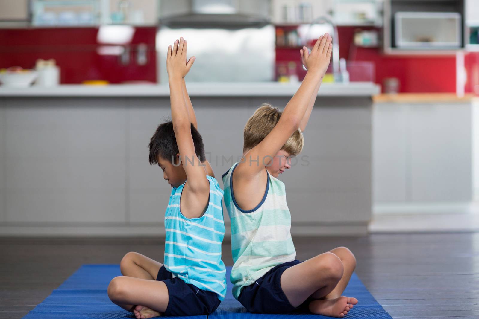 Siblings performing yoga at home by Wavebreakmedia