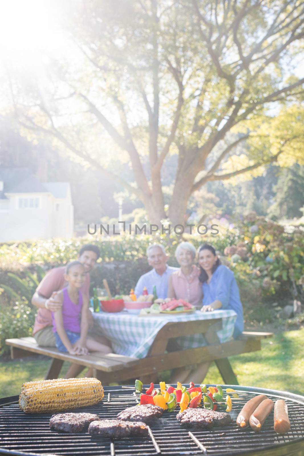Close-up of barbecue and family sitting on the table by Wavebreakmedia