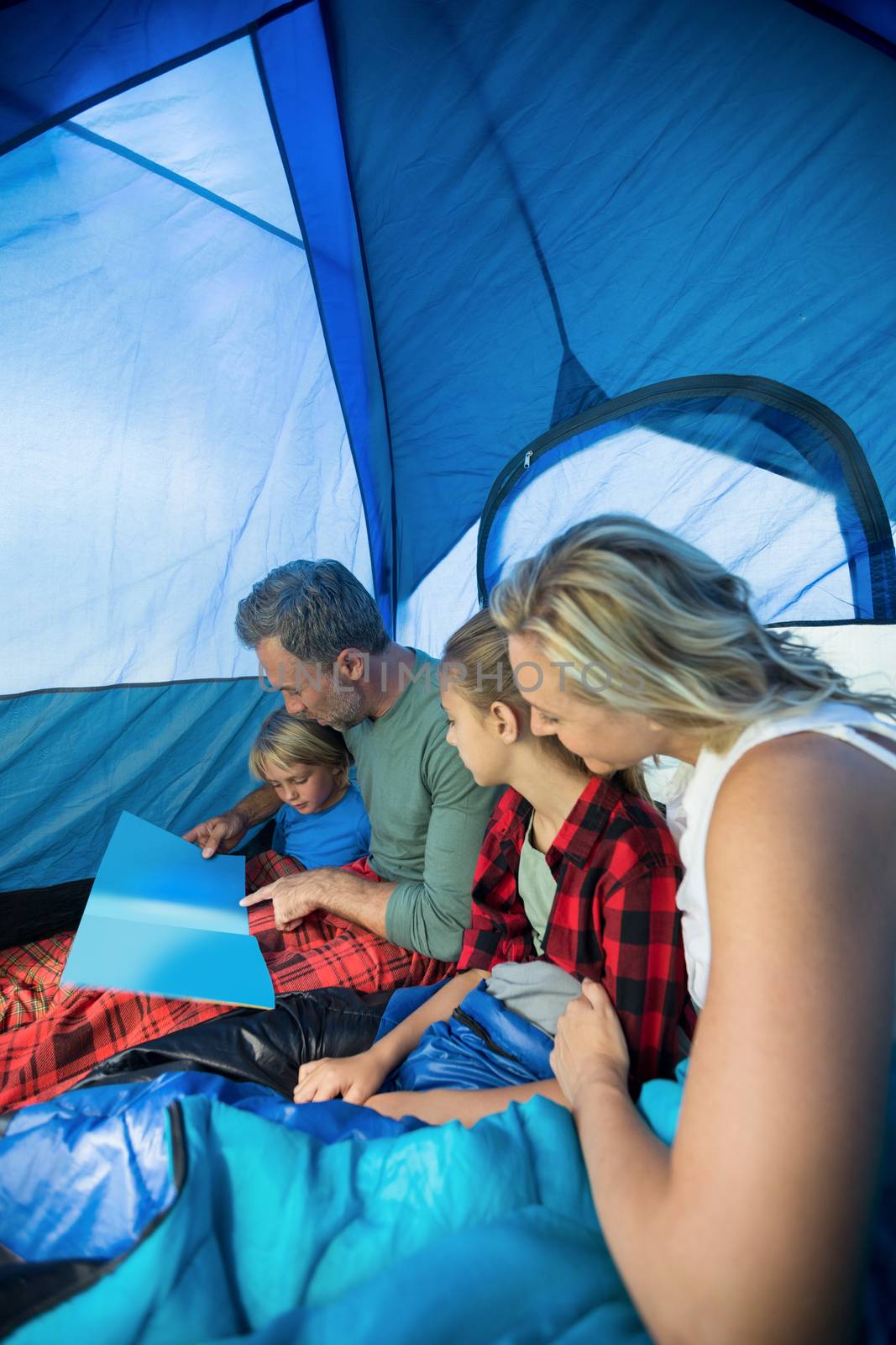 Family reading book in the tent by Wavebreakmedia