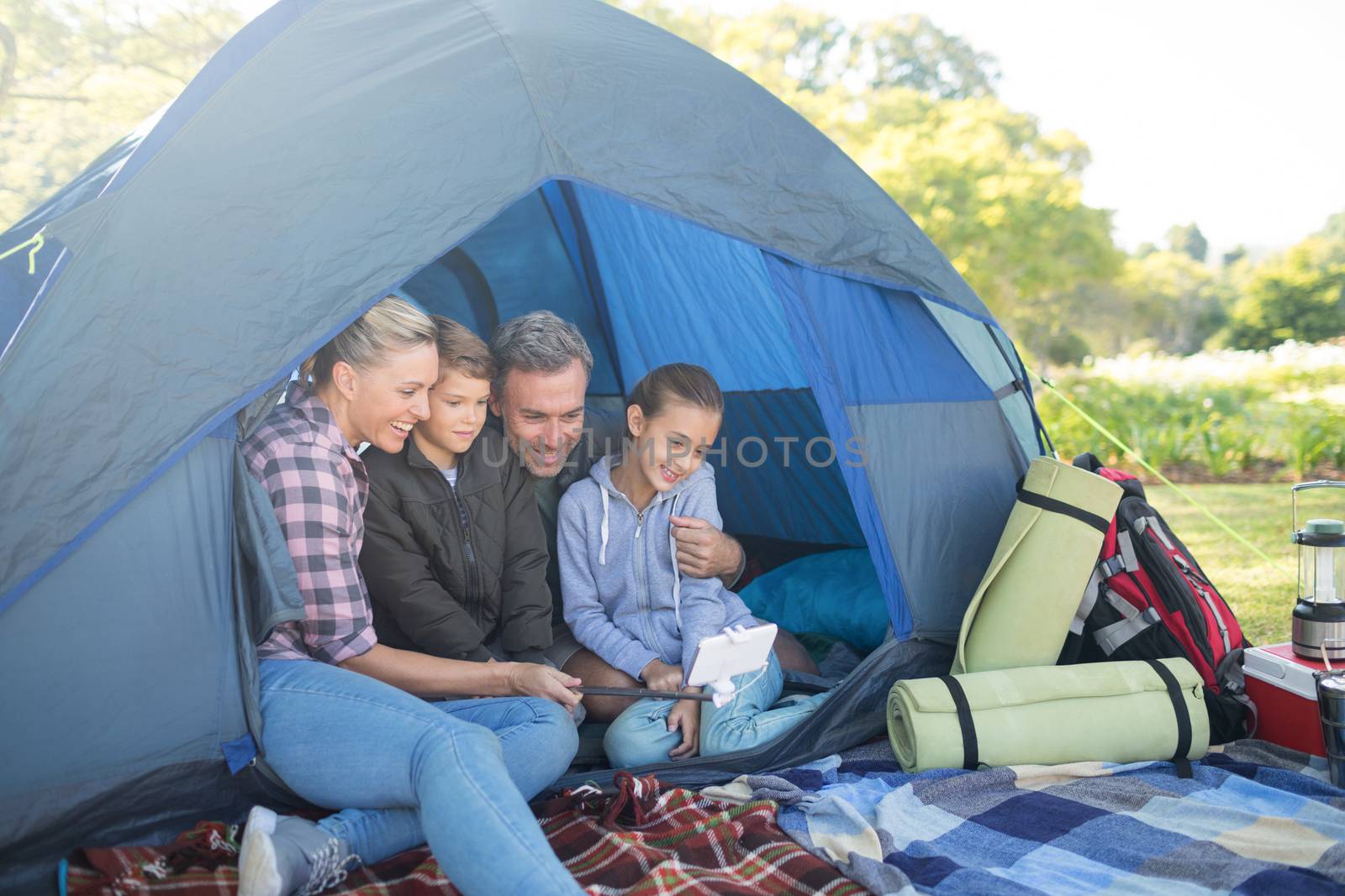 Family taking a selfie in the tent by Wavebreakmedia
