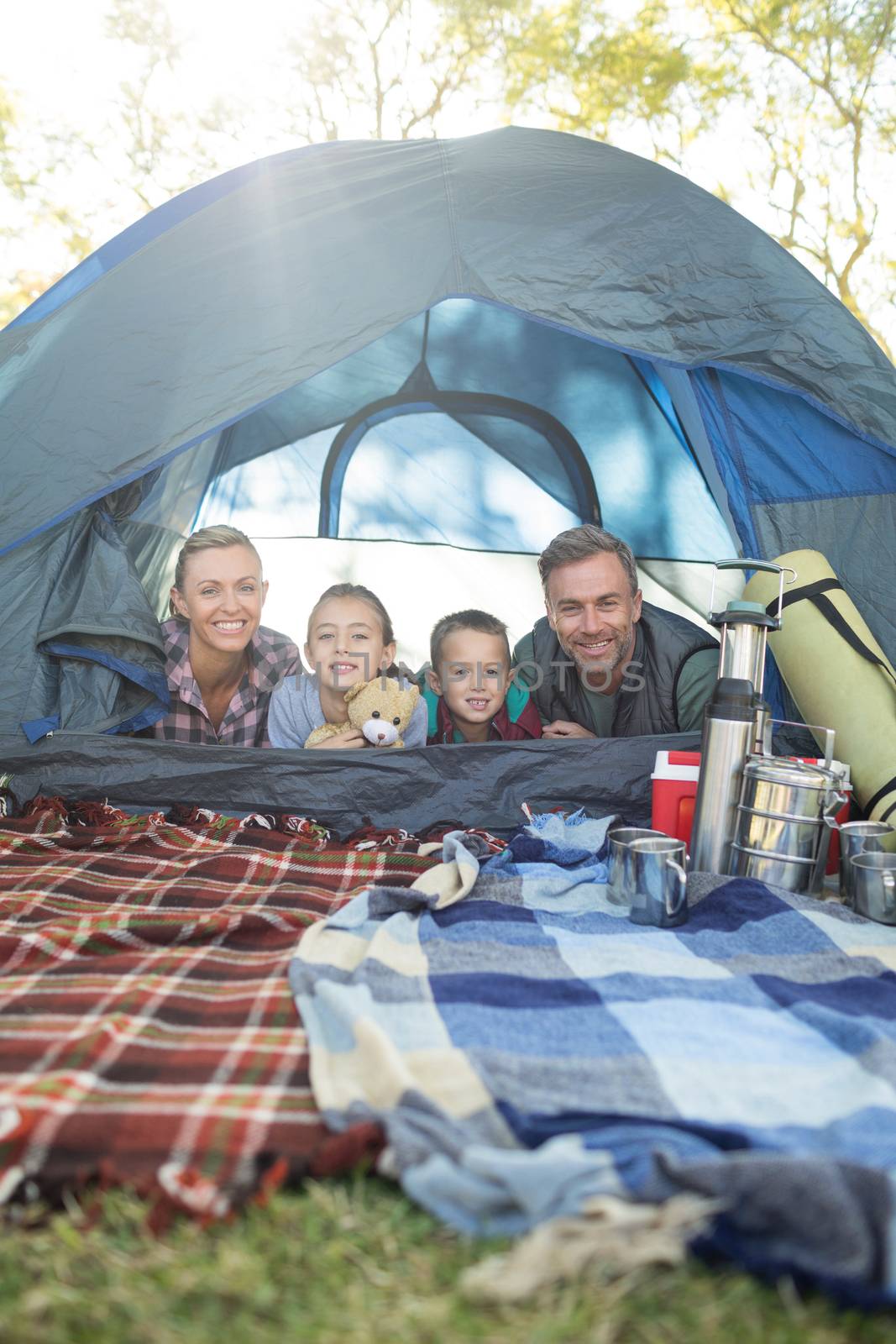 Smiling family lying in the tent by Wavebreakmedia