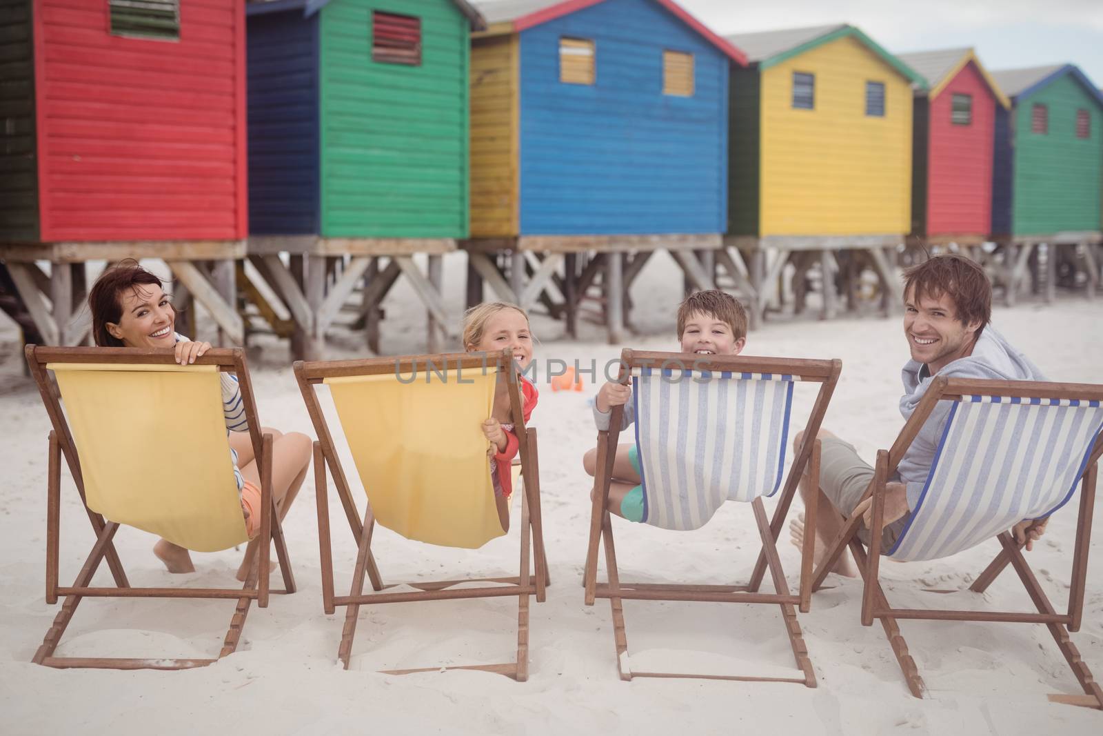 Portrait of family resting on lounge chairs by Wavebreakmedia