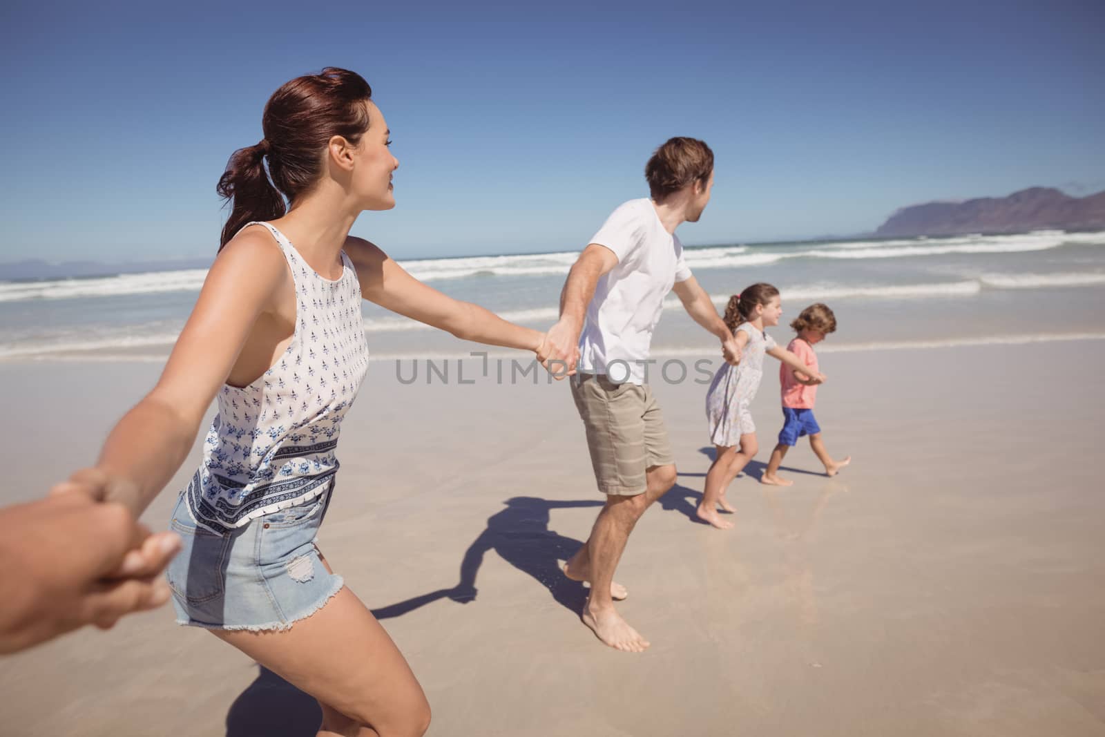 Family holding hands at beach by Wavebreakmedia