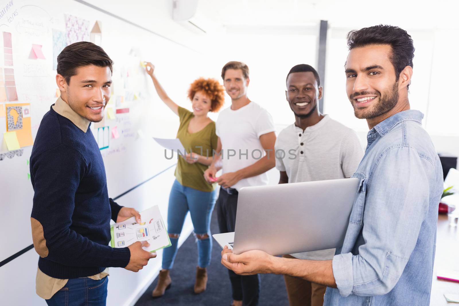 Portrait of business people against whiteboard in office