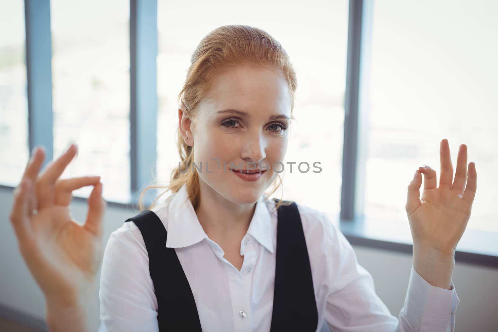 Portrait of smiling executive performing yoga in office