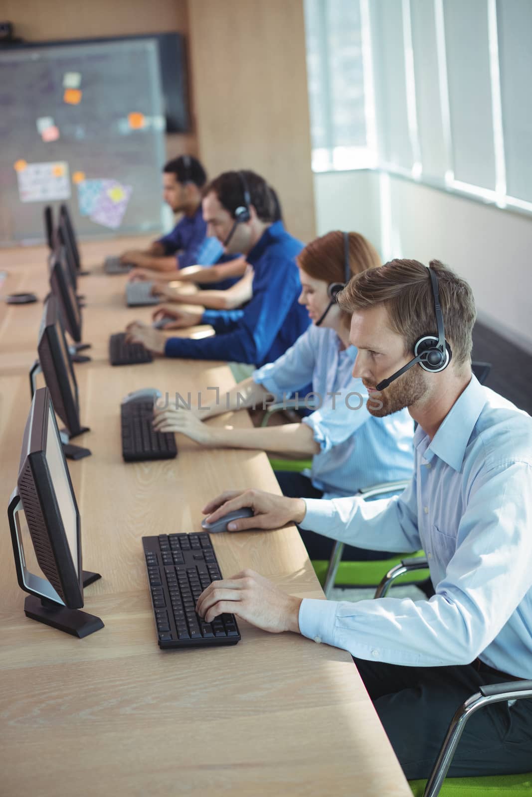 High angle view of business people working at desk in call center