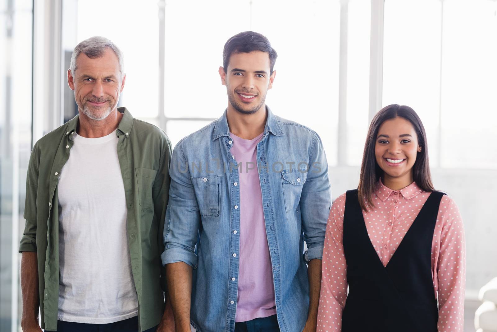 Portrait of smiling business people standing side by side in office