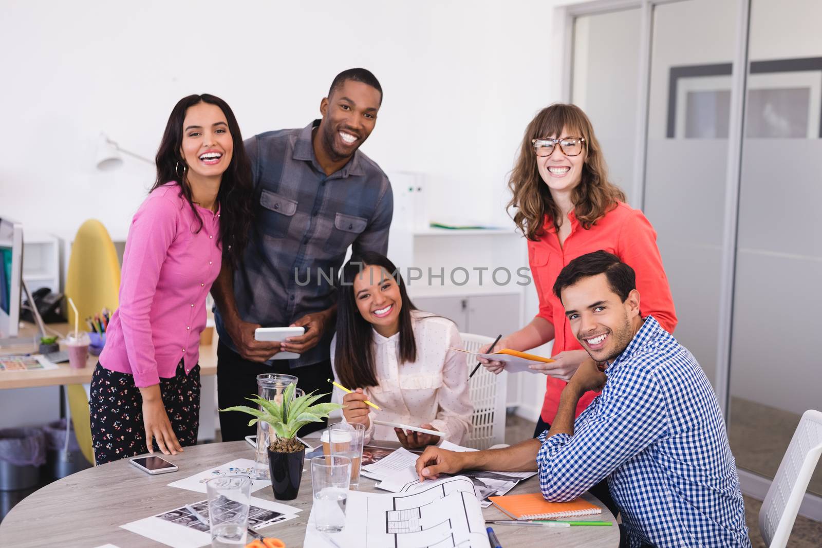 Smiling business people at desk by Wavebreakmedia