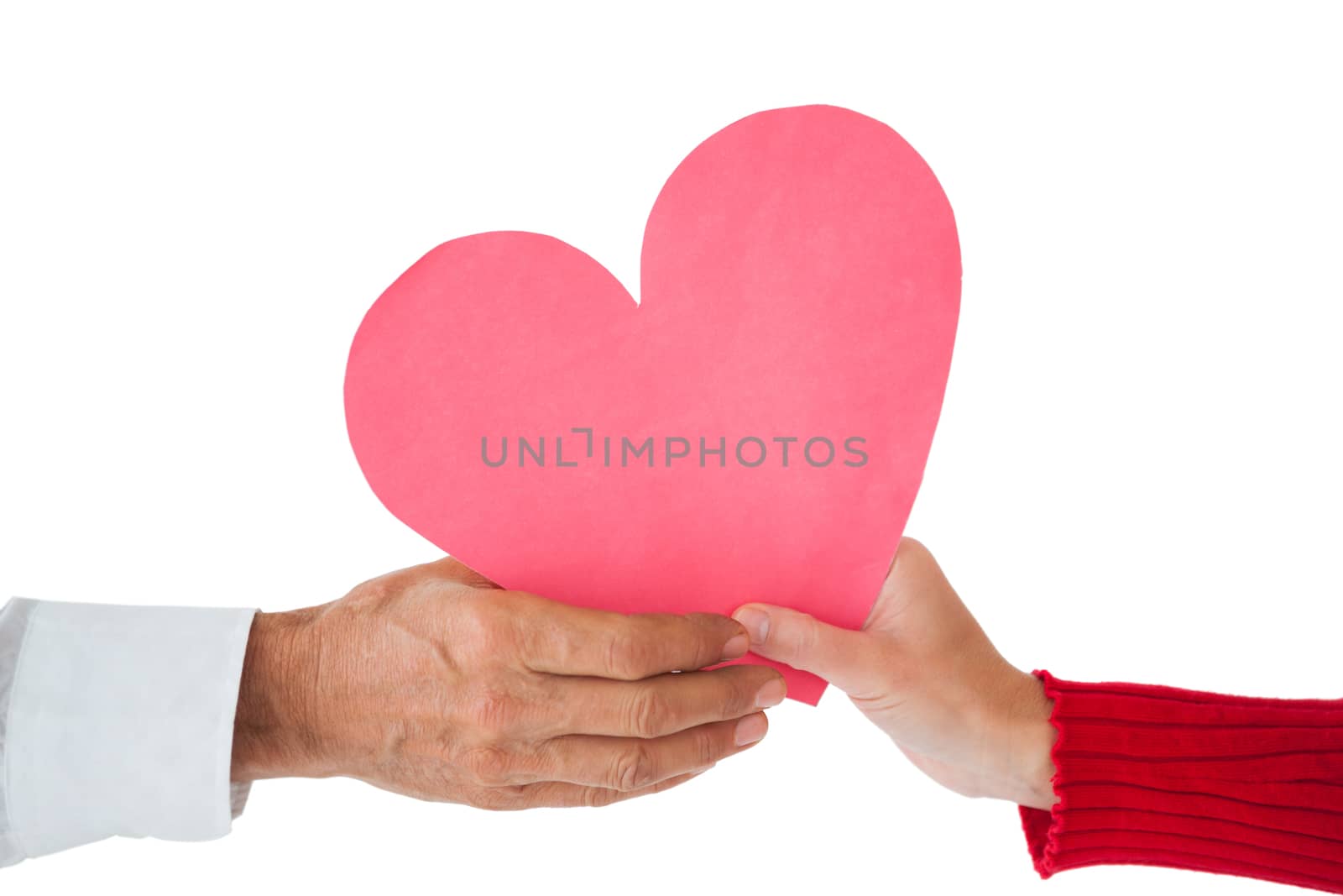 Couple passing a paper heart on white background