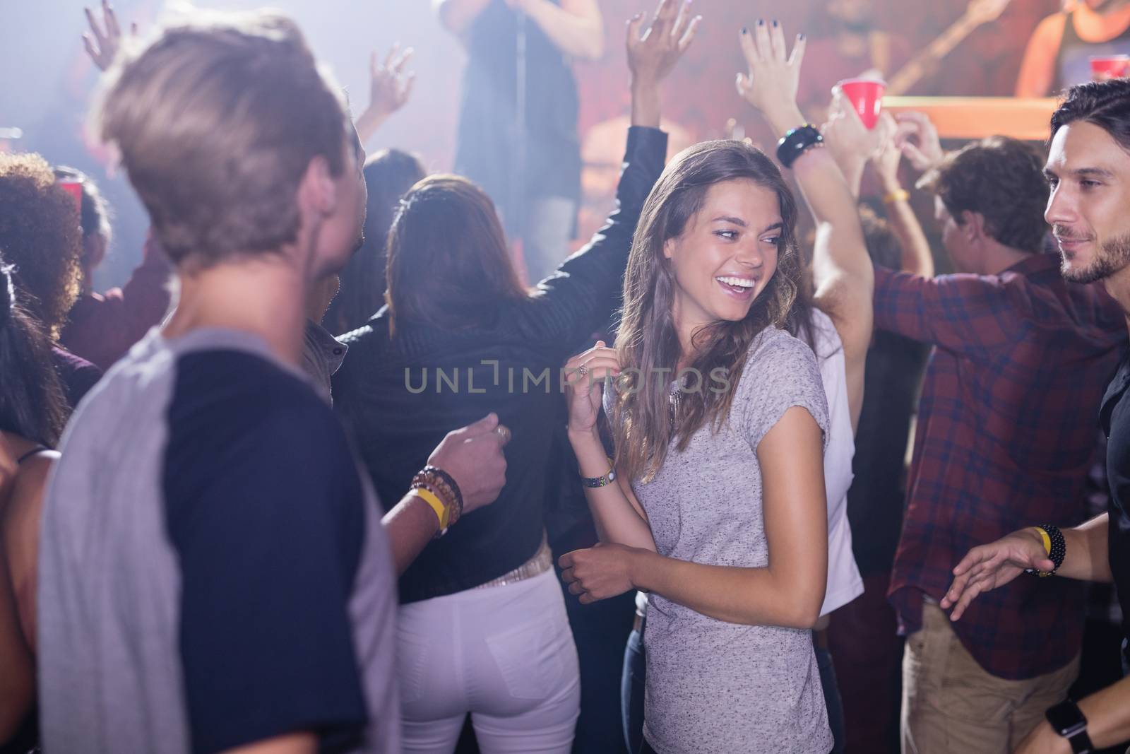 Happy people dancing at nightclub by Wavebreakmedia