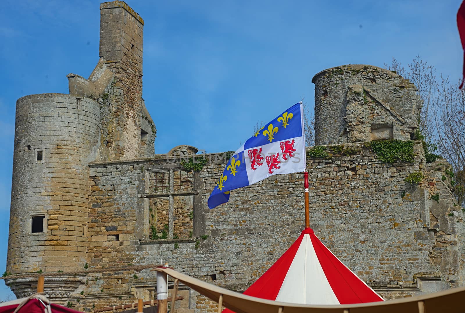 Top of medieval red and white tent with normandy flag at top and castle in background by sheriffkule