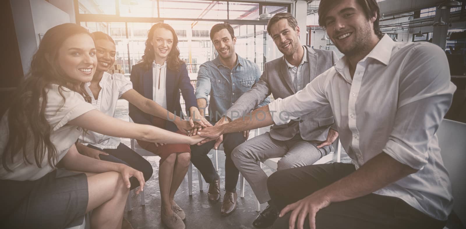 Portrait of business people forming hand stack in office