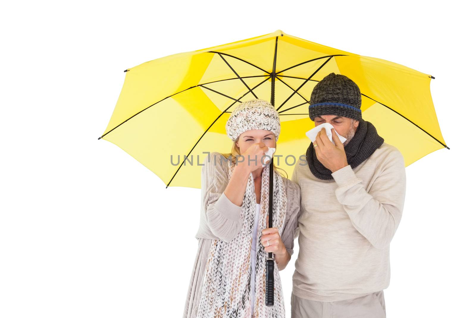 Couple in winter fashion sneezing under umbrella by Wavebreakmedia